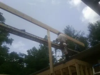 Carpenter setting a ridge beam over a new addition frame — Ice Dam Removal by Roofing Brothers in Clarks Summit