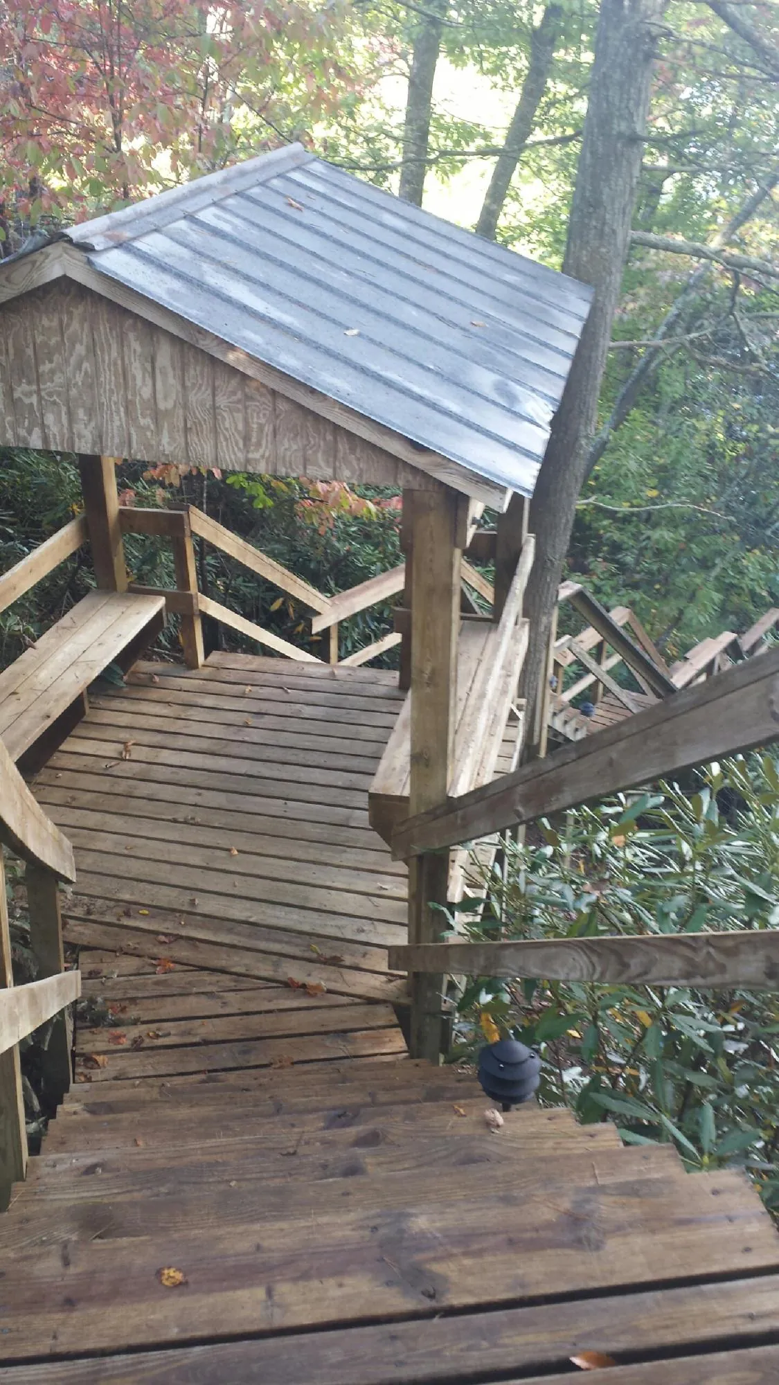 Metal roofed shelter over wooden steps on a wooded walkway — Skylight Repair & Installation work by our crew in Clarks Summit