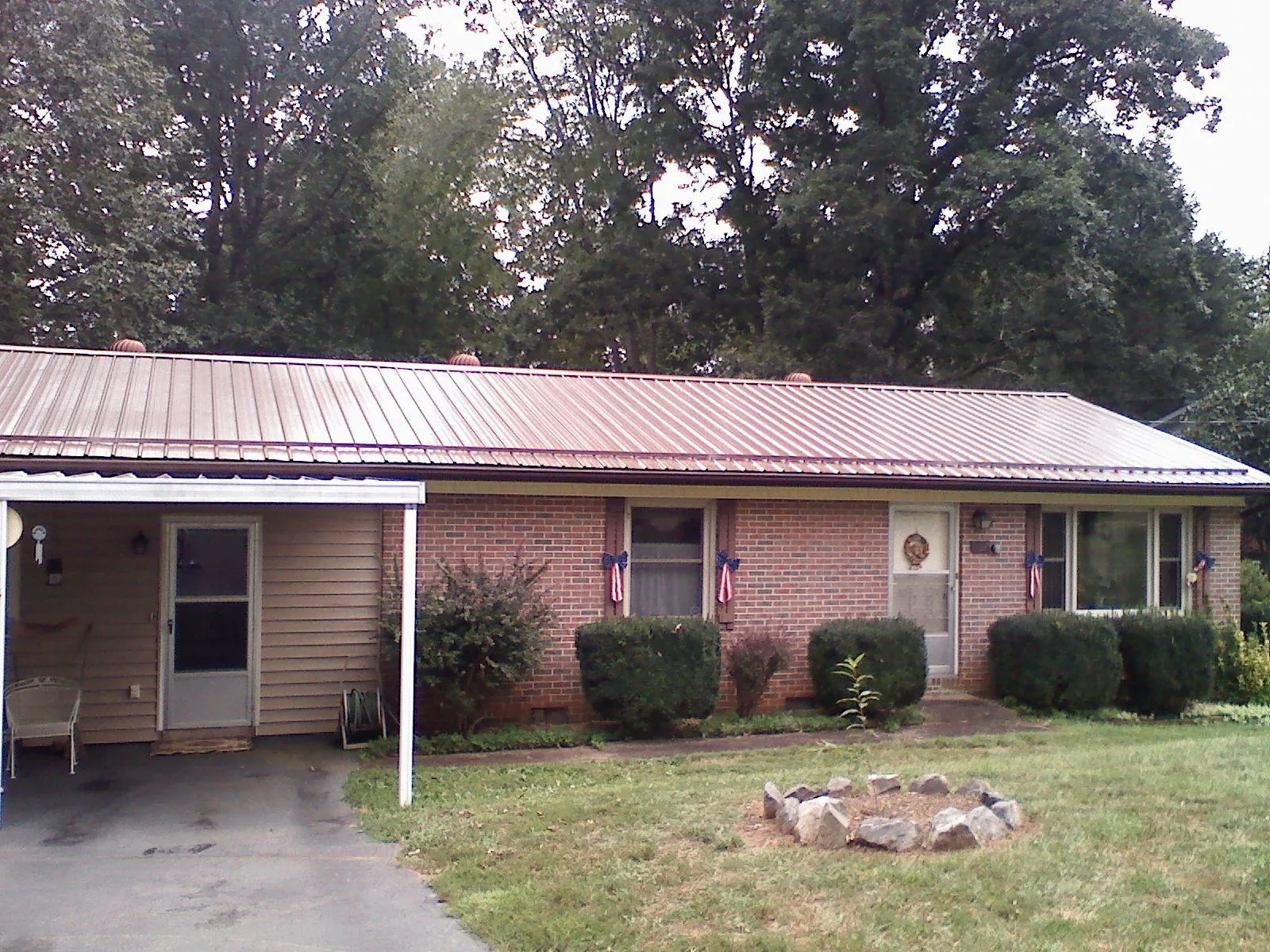 Bronze metal roof and carport on a brick ranch home — Roof Repair work by our crew in Clarks Summit